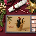 Weihnachtslicher Geschenketisch mit geöffnetem Adventskalender, schwarzer Kater mit NIkolausmütze auf dem Titel